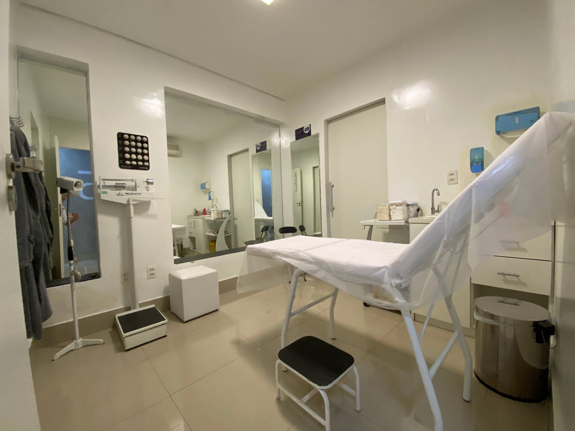 Um consultório médico com uma cama e um espelho.