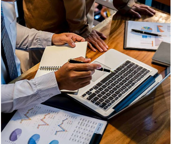 Contadores analisando dados e planilhas em papel e no laptop Contadores analisando dados nas planilhas e laptops