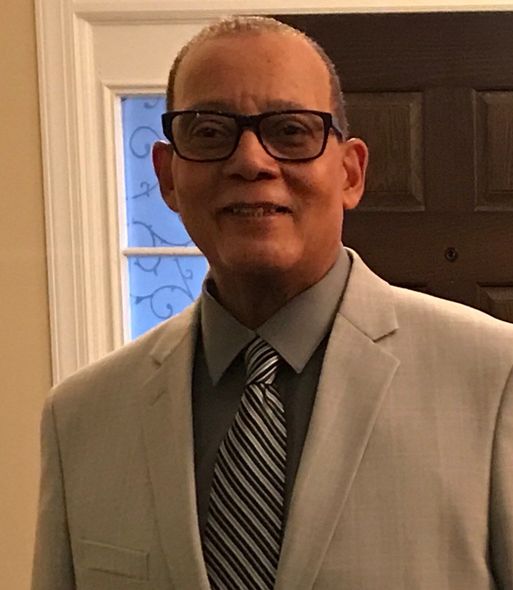 A man in a suit and tie is smiling for the camera.