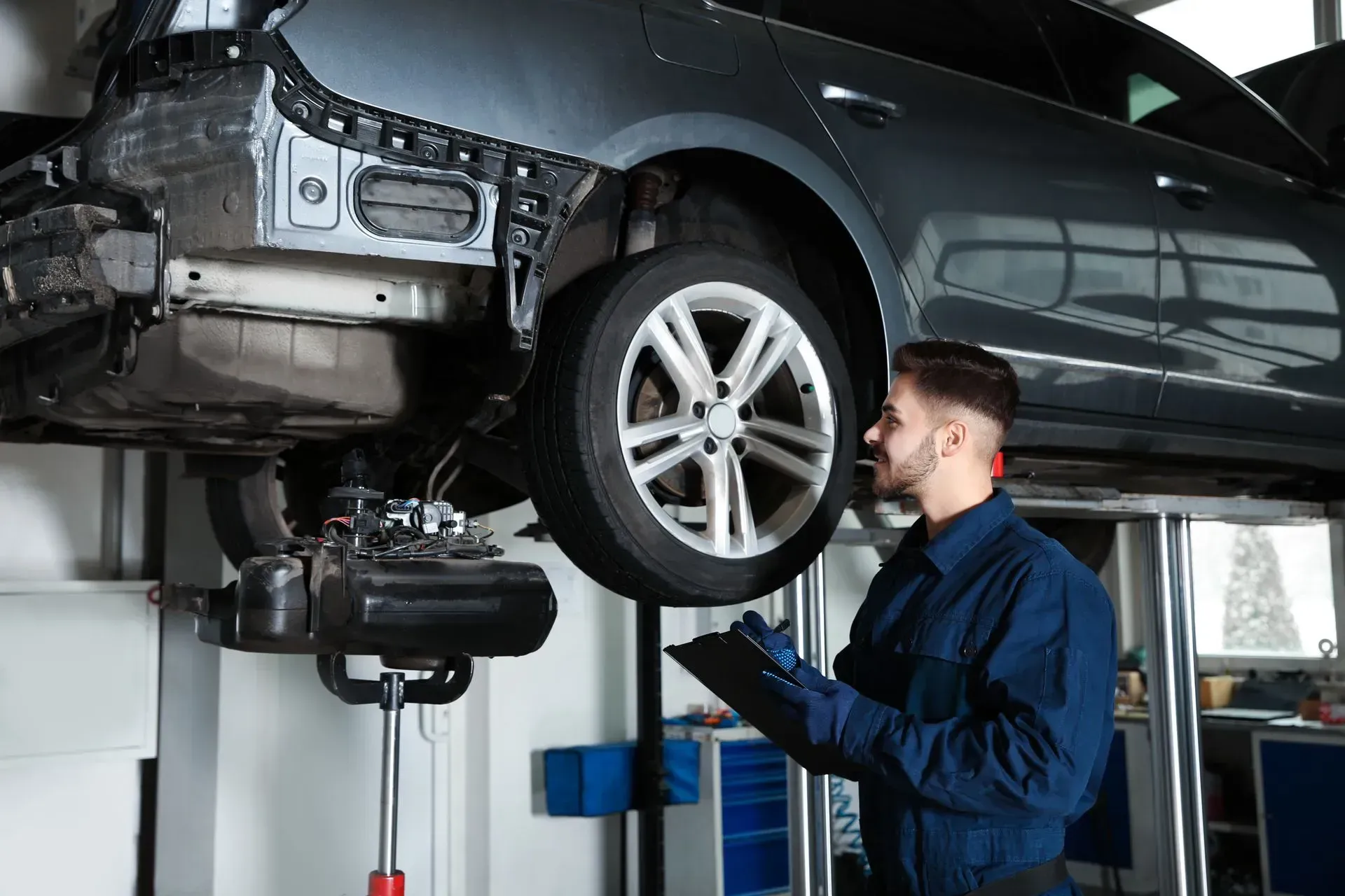 Mechanic inspecting a car on a lift in an auto repair shop