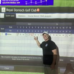 A man standing in front of a screen that says royal dornoch golf club