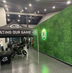 A large room with a green wall and a tent that says `` eating our game ''.