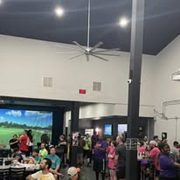 A group of people are sitting at tables in a large room.