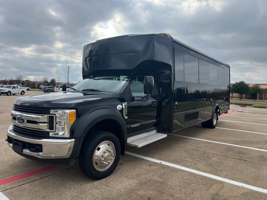Bus driving on a city street in front of a brick building with the words
