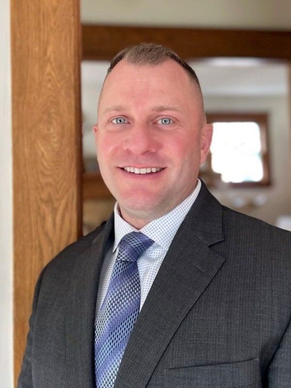 A man in a suit and tie is smiling for the camera.