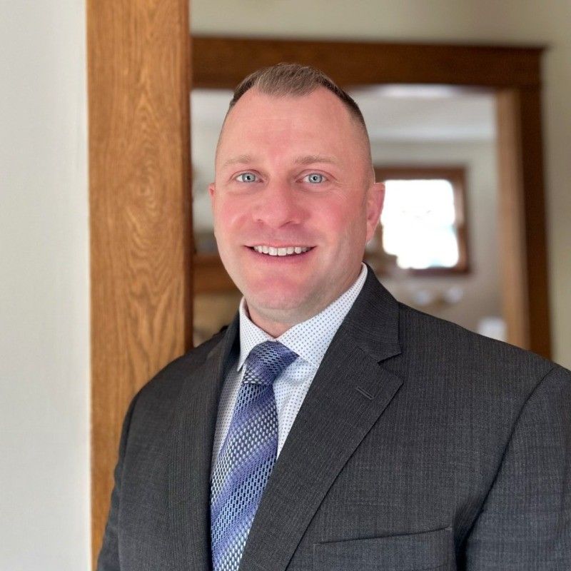 A man in a suit and tie is smiling for the camera.