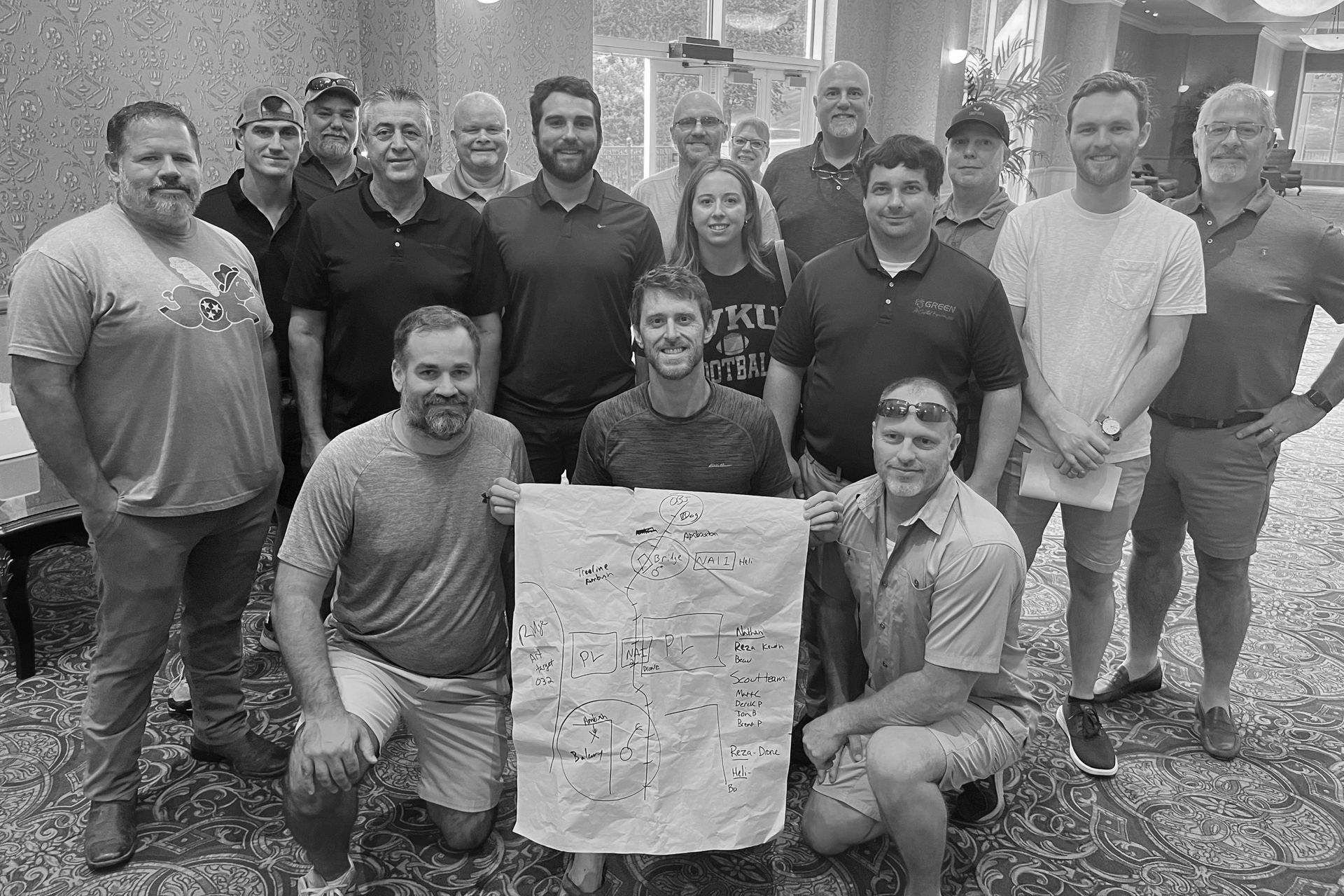 A group of people are posing for a picture while holding a sign.