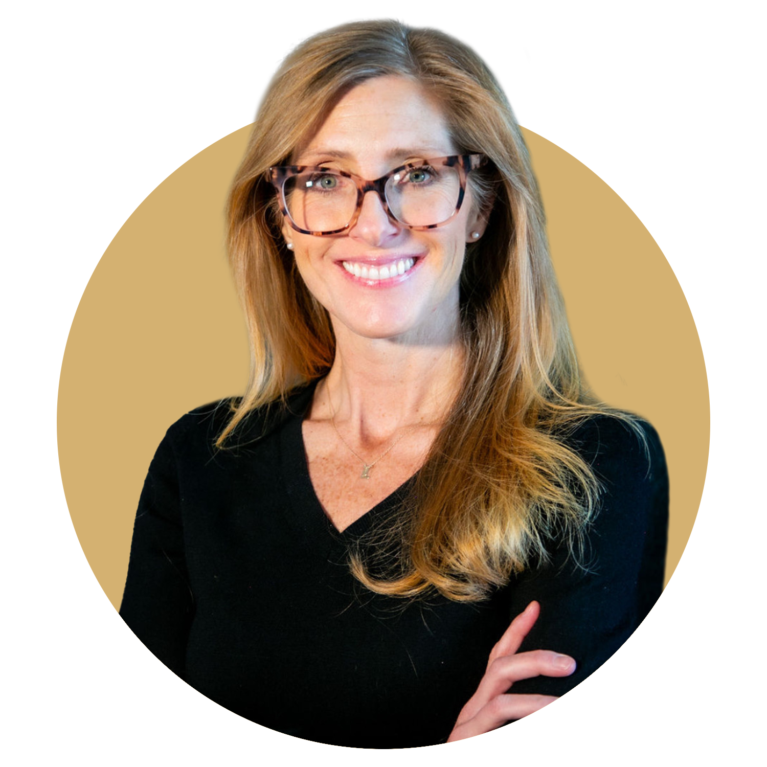A man in a suit and white shirt is smiling in front of a tree.