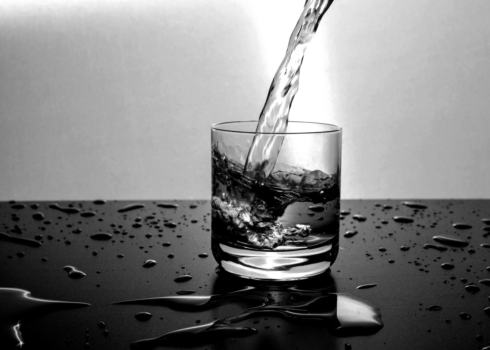 Water is being poured into a glass on a table