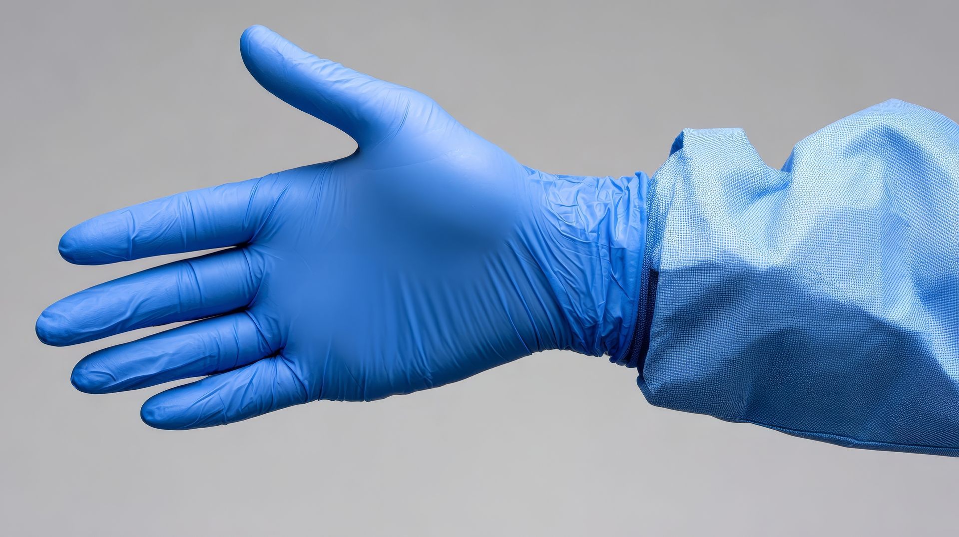 Blue gloved hand reaching forward, sleeve visible, against a gray background.