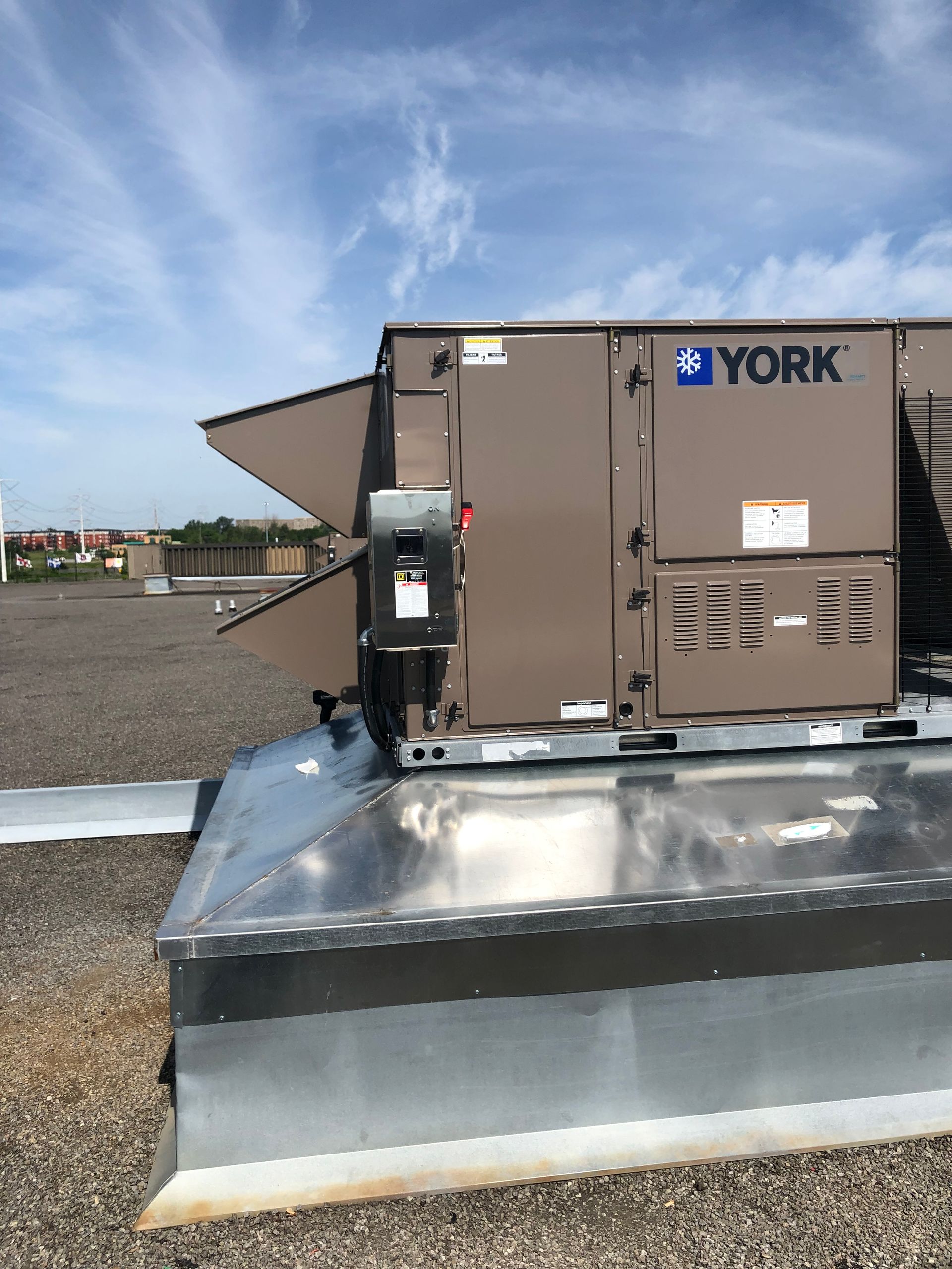Une unité CVC sur le toit de York sur un toit commercial, avec un fond de ciel bleu.