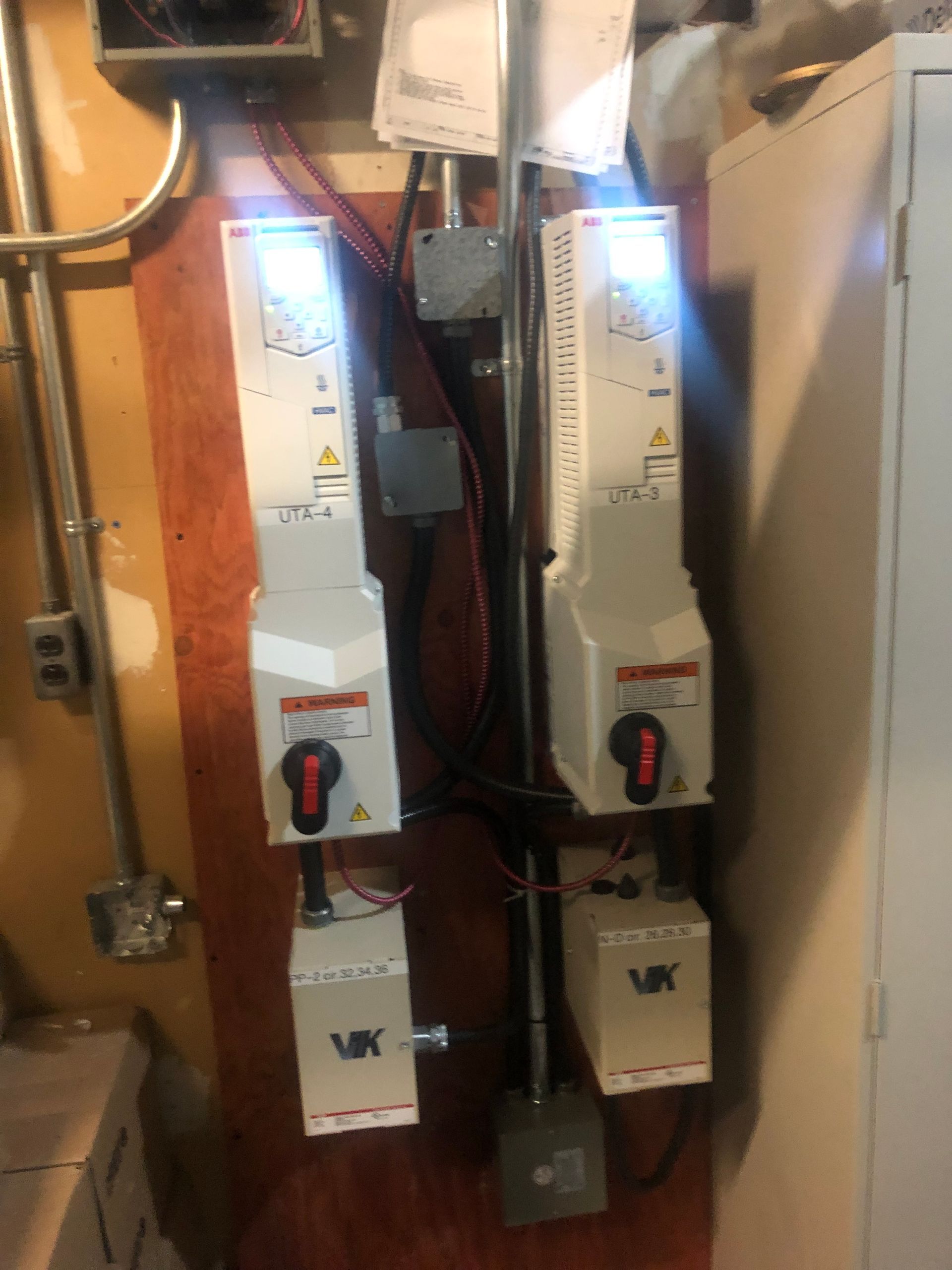 Deux interrupteurs de déconnexion électriques montés sur un panneau de bois dans une buanderie.