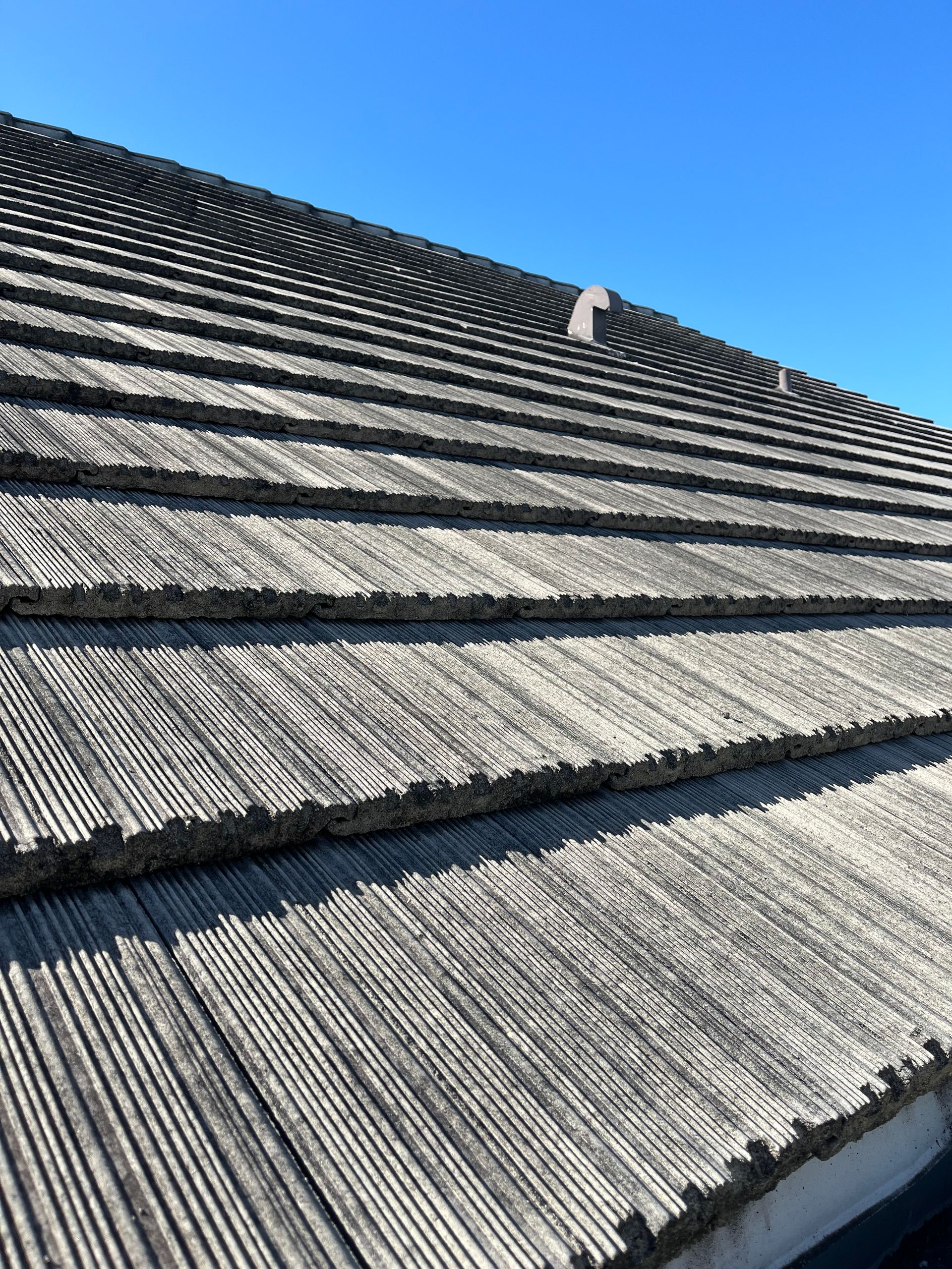 A close up of a roof with a blue sky in the background