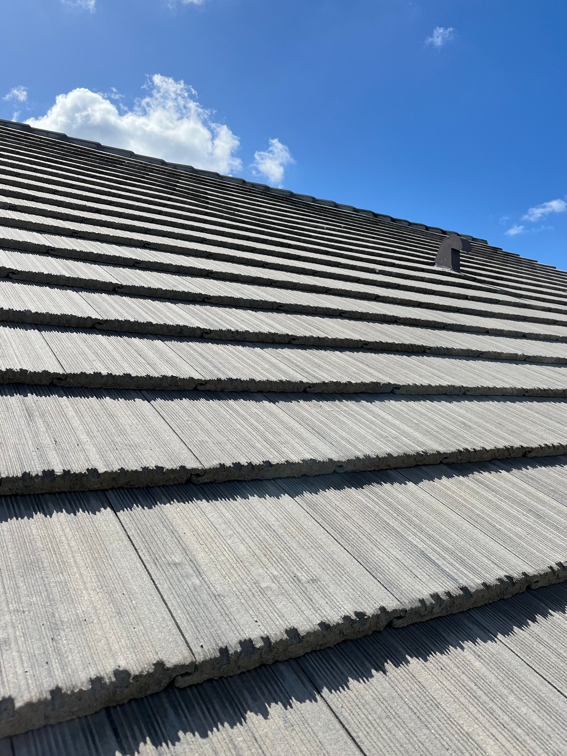 A close up of a roof with a blue sky in the background