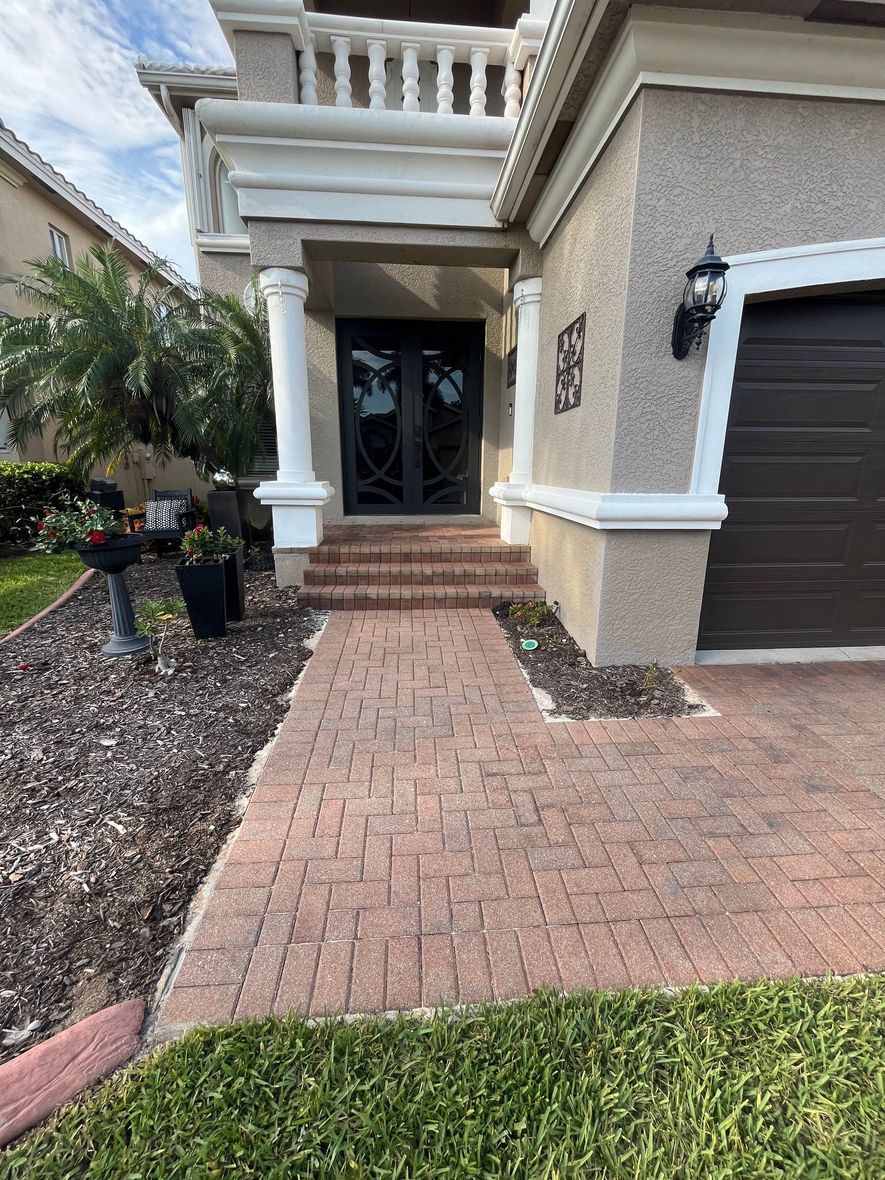 A brick walkway leading to the front door of a house.