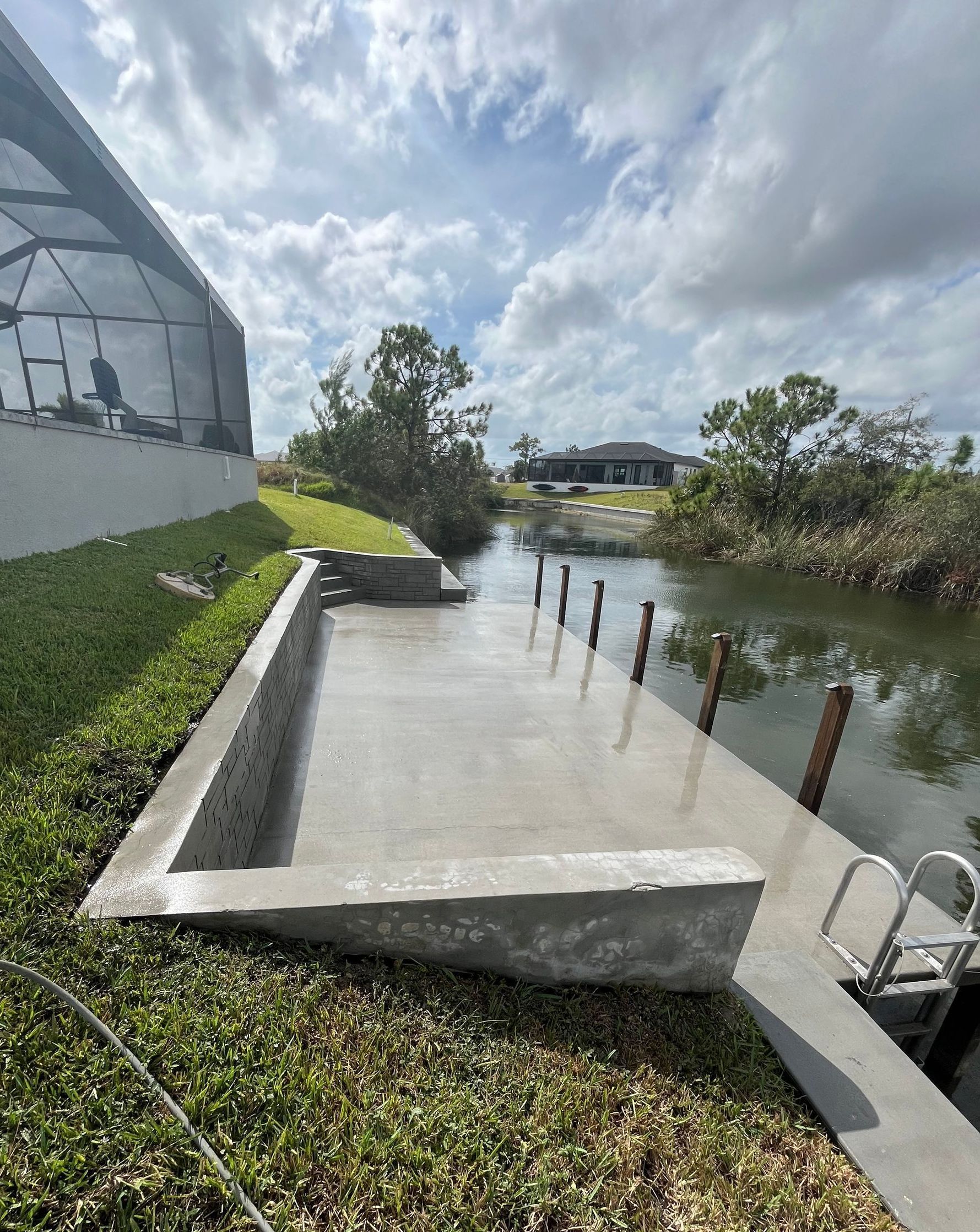 A concrete dock is sitting next to a body of water.