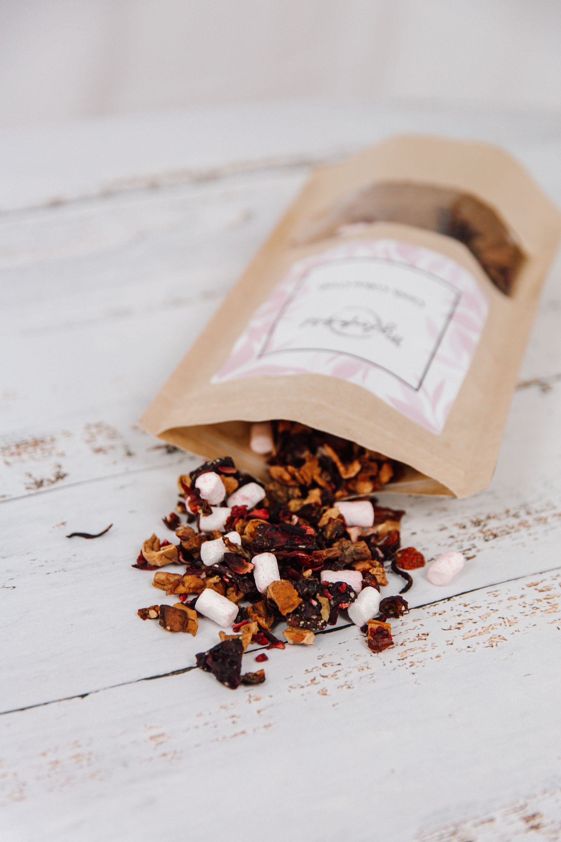 eine braune Tüte mit einem rosa Aufkleber liegt auf einem Holztisch