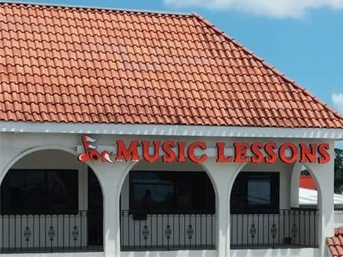 Piano instructor Virginia Beach, VA: A white building with a red roof and a sign that says music lessons