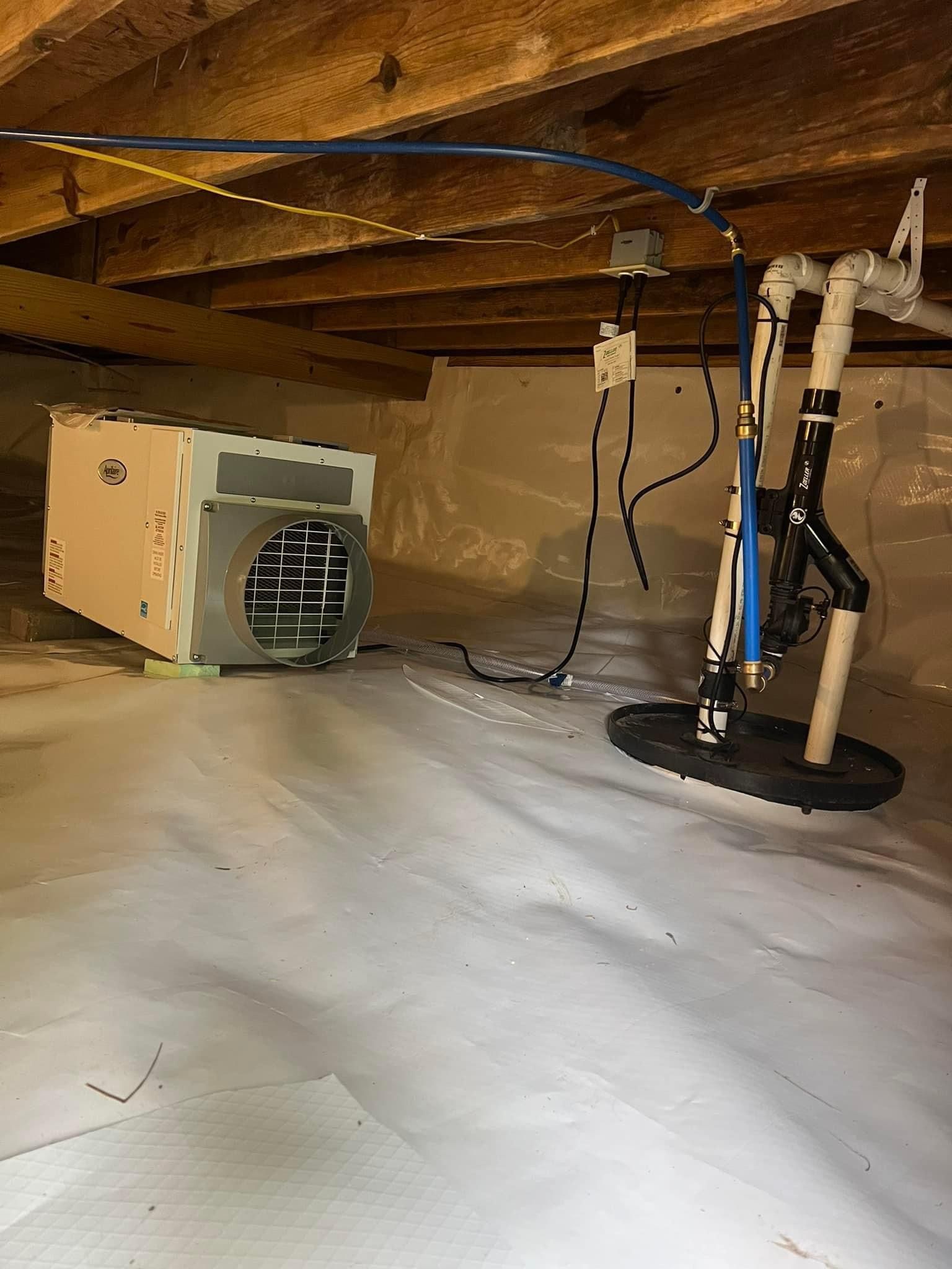 A basement with a humidifier and a sump pump.