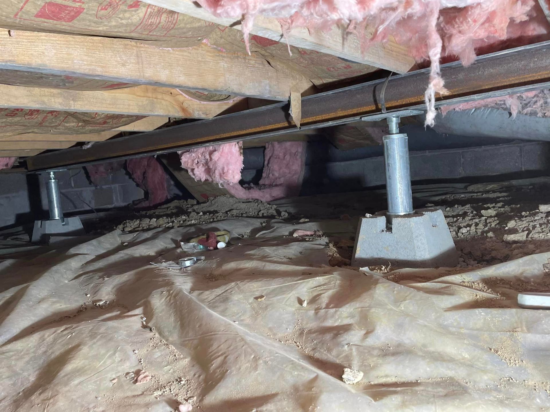 There is a lot of insulation in the crawl space of a house.