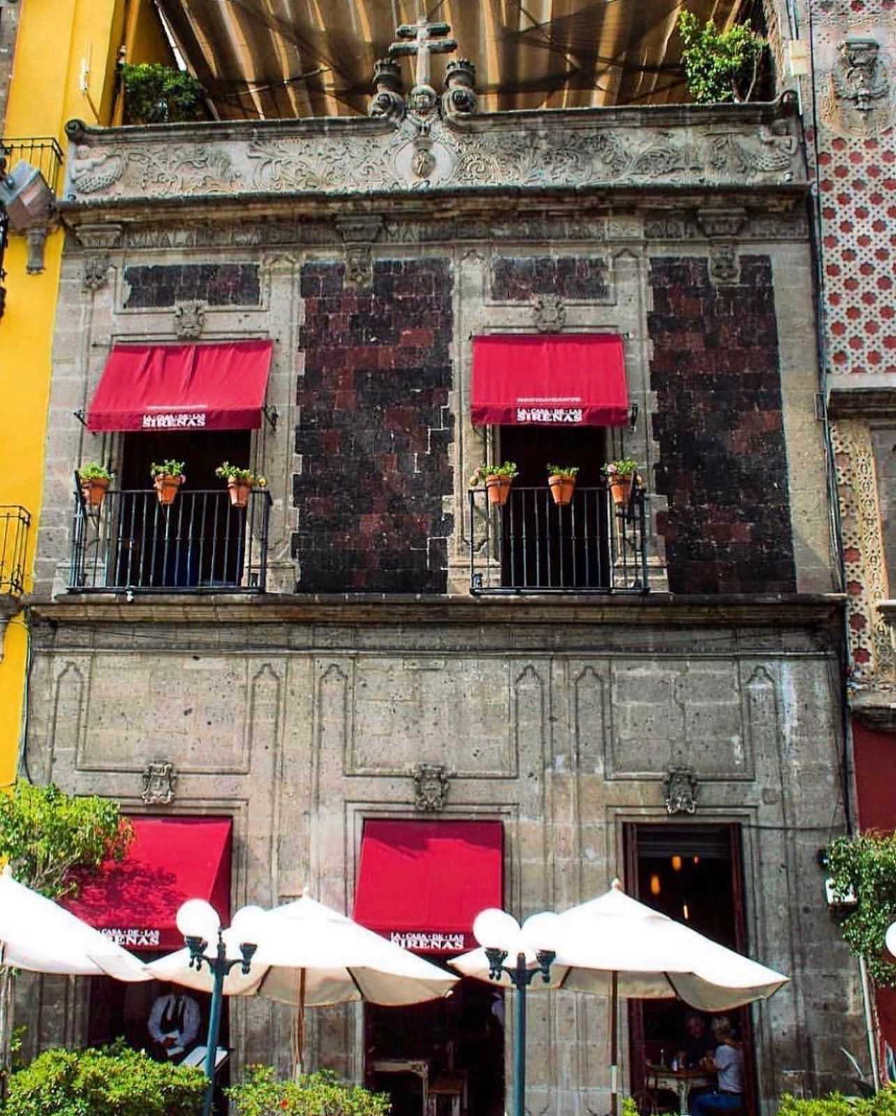 Un edificio con un toldo rojo que dice 