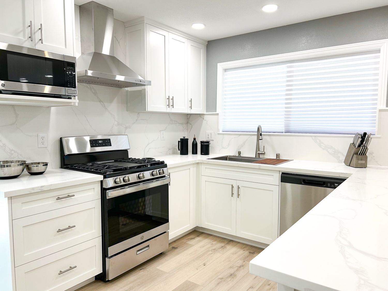 White custom cabinets in a completed kitchen.