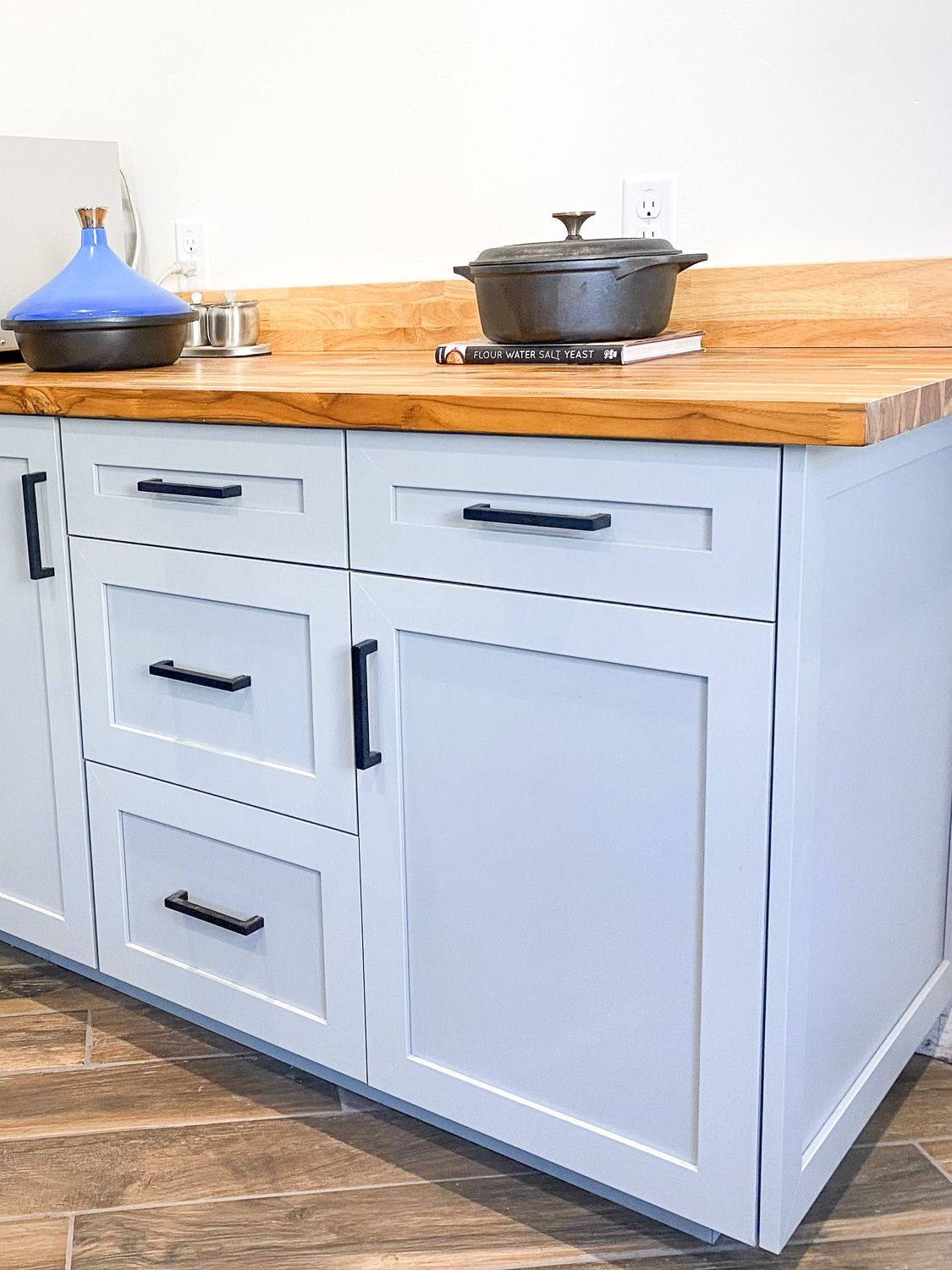  Wood countertop, black hardware, and cookware.