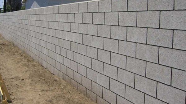 a person is using a trowel to spread cement on a wall