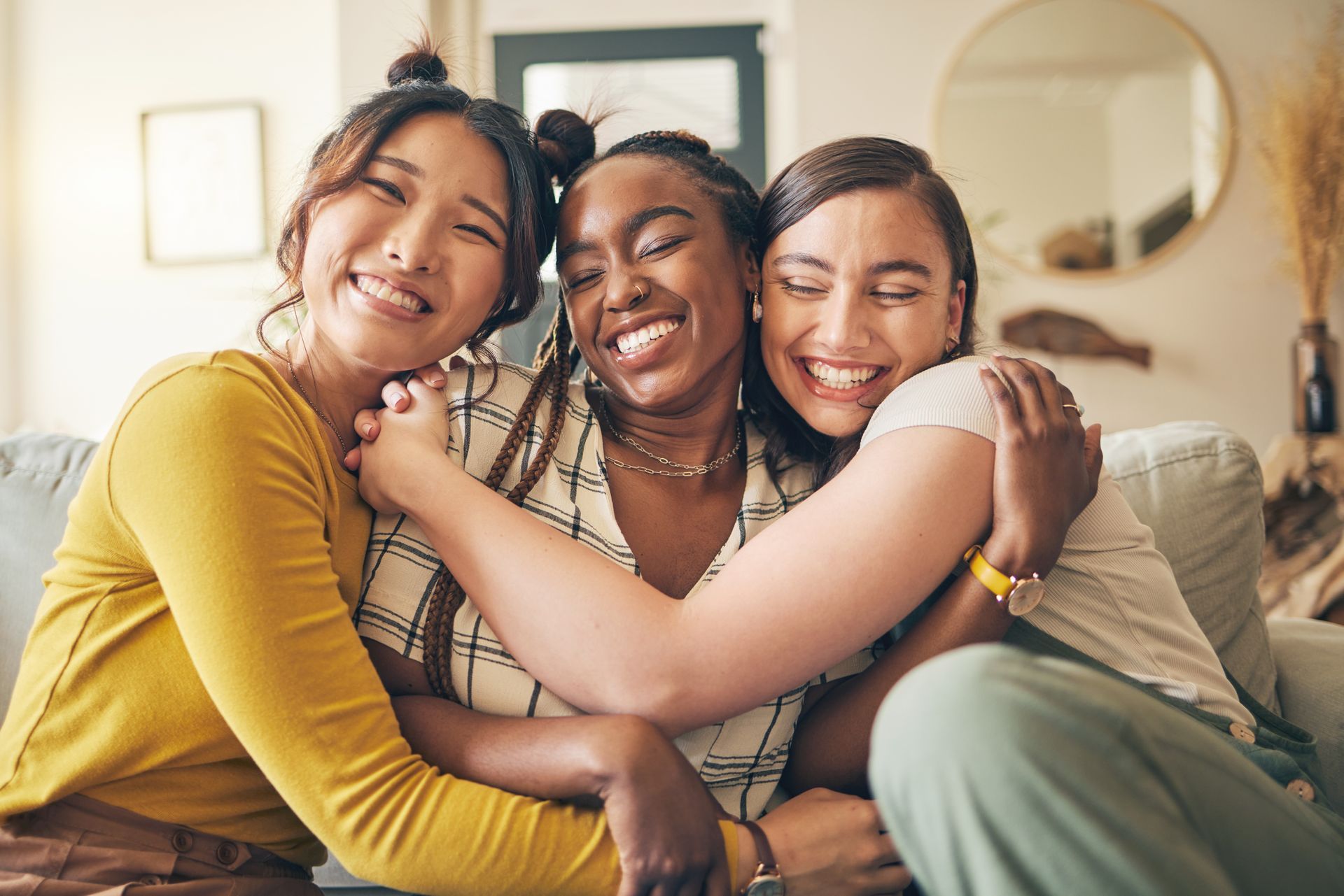 Friends hanging out in an apartment on the couch.