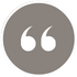 Gray circular icon with white quotation marks