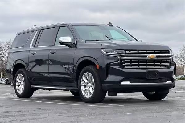 Black Chevrolet SUV parked on a wet lot under an overcast sky