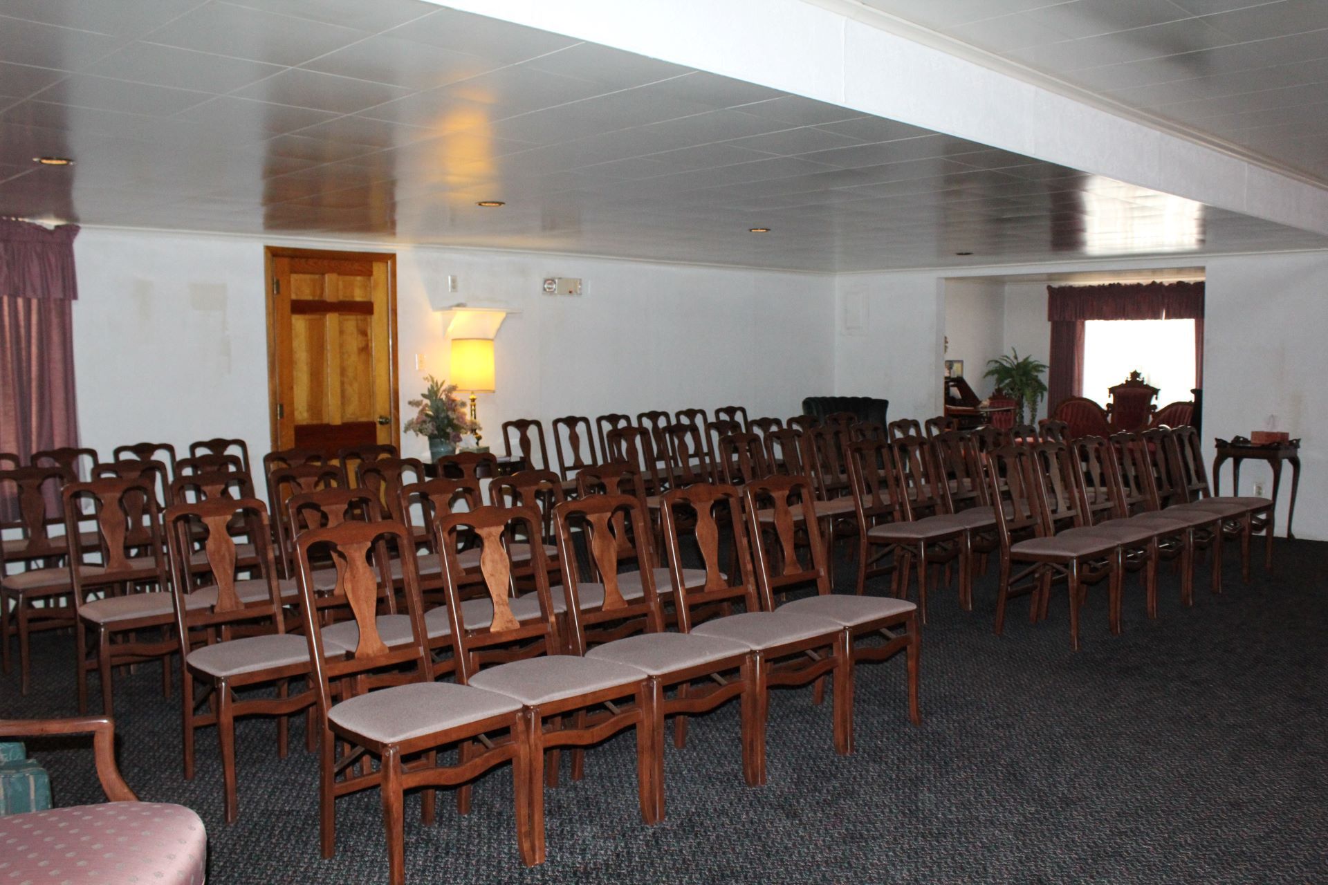 Rows of wooden chairs are lined up in a room