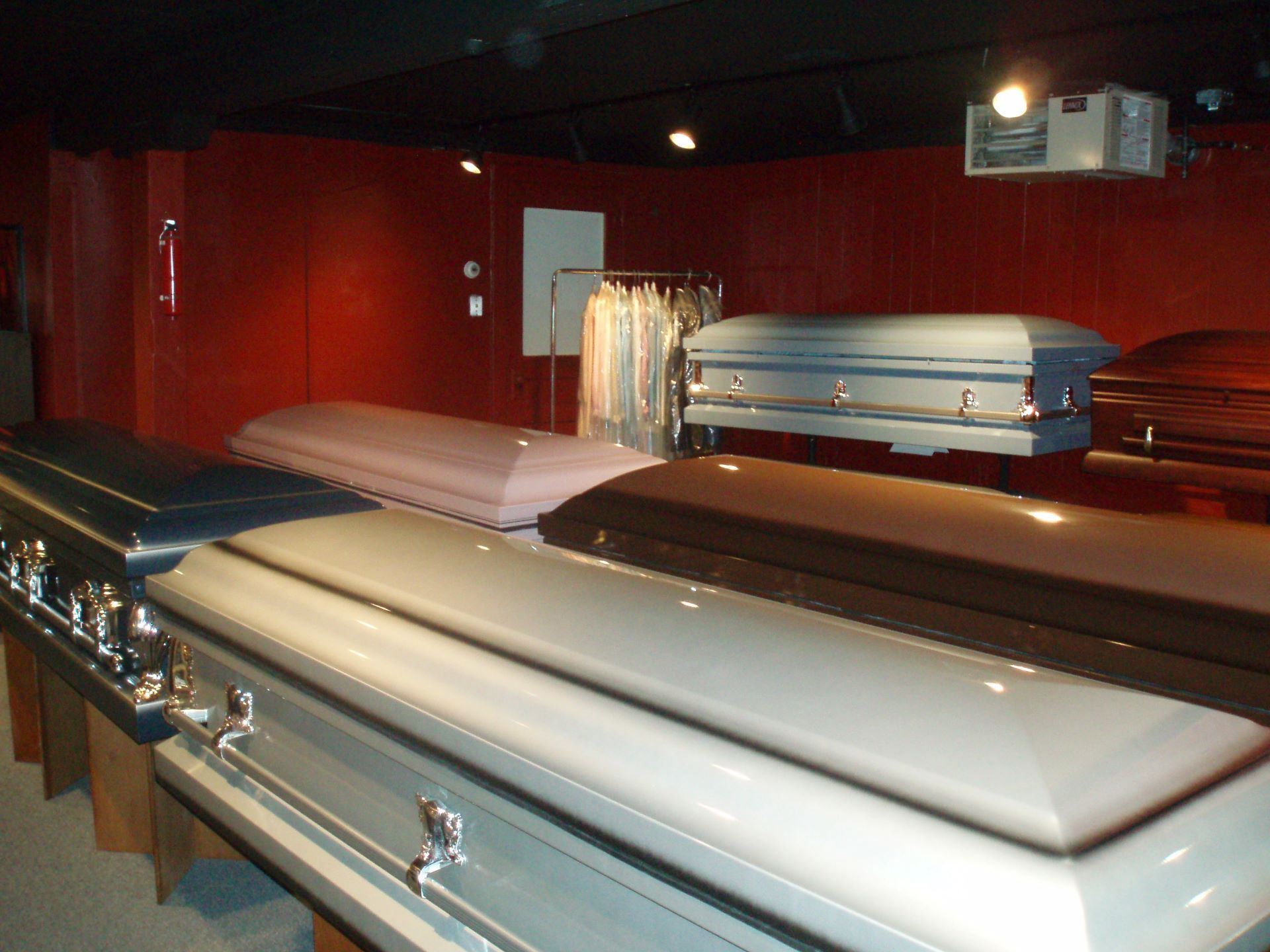 A row of coffins are lined up in a room