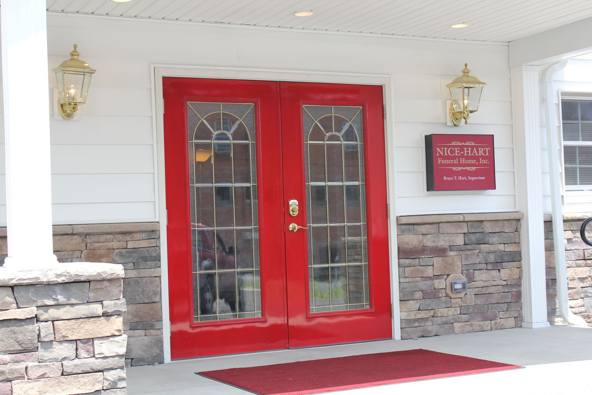 A red door with a sign that says ' the plaza ' on it