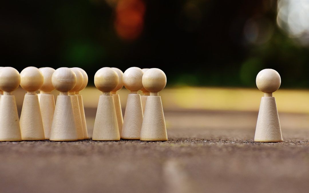 A group of wooden peg dolls standing next to each other on a table.