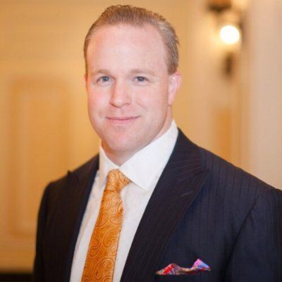 A man in a suit and tie is smiling for the camera
