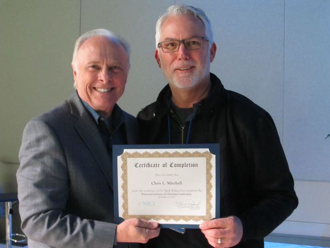 Dr. Mark Rutland standing next to a pastor holding a certificate that says certificate of completion