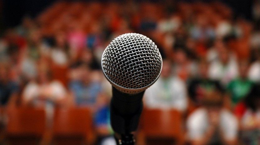 A microphone is sitting in front of a crowd of people.