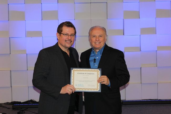 Two men standing next to each other holding a certificate