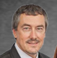 A man in a suit and tie is smiling for the camera.