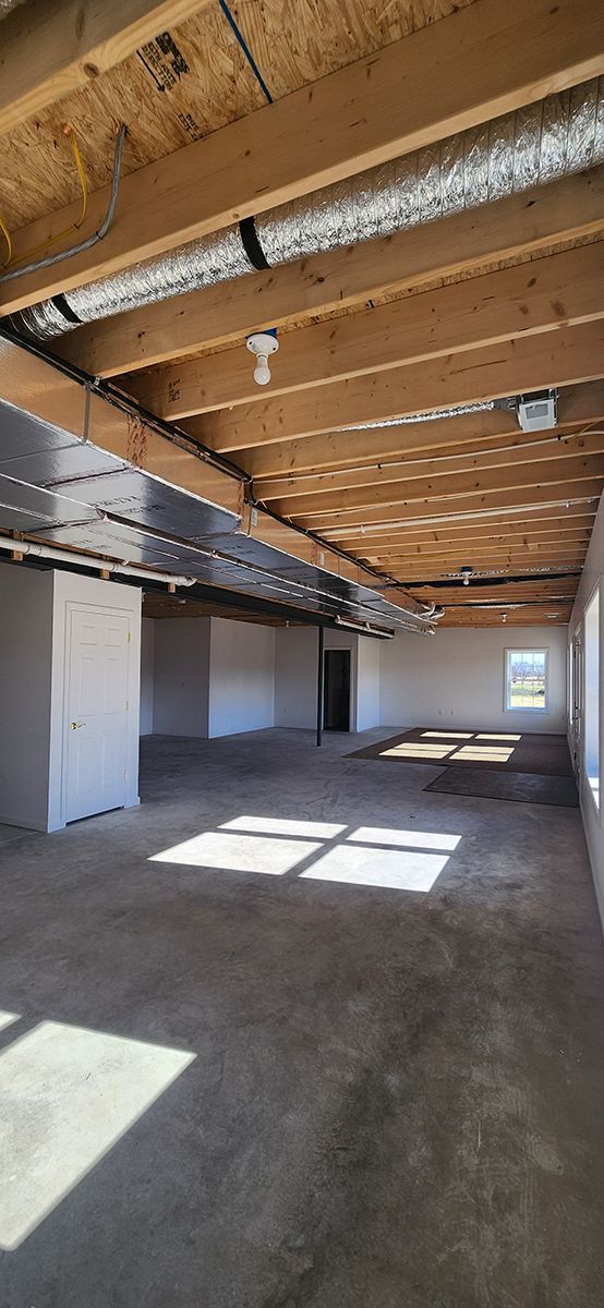 basement with a unfinished ceiling and a lot of windows.