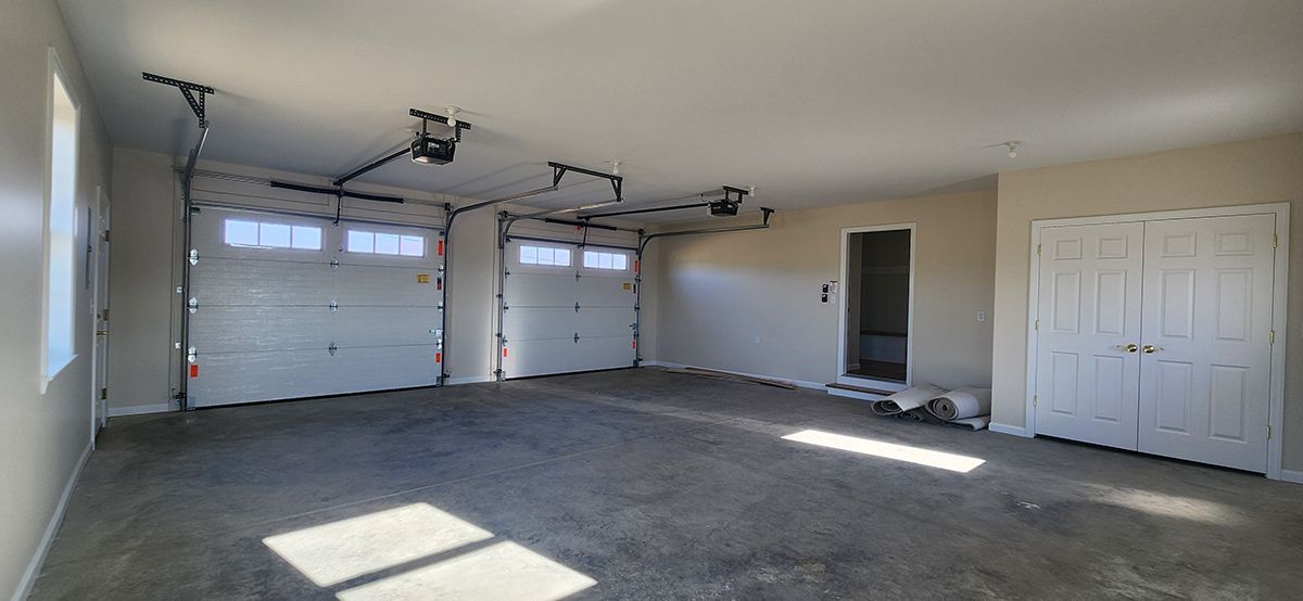 A large empty garage with two garage doors 