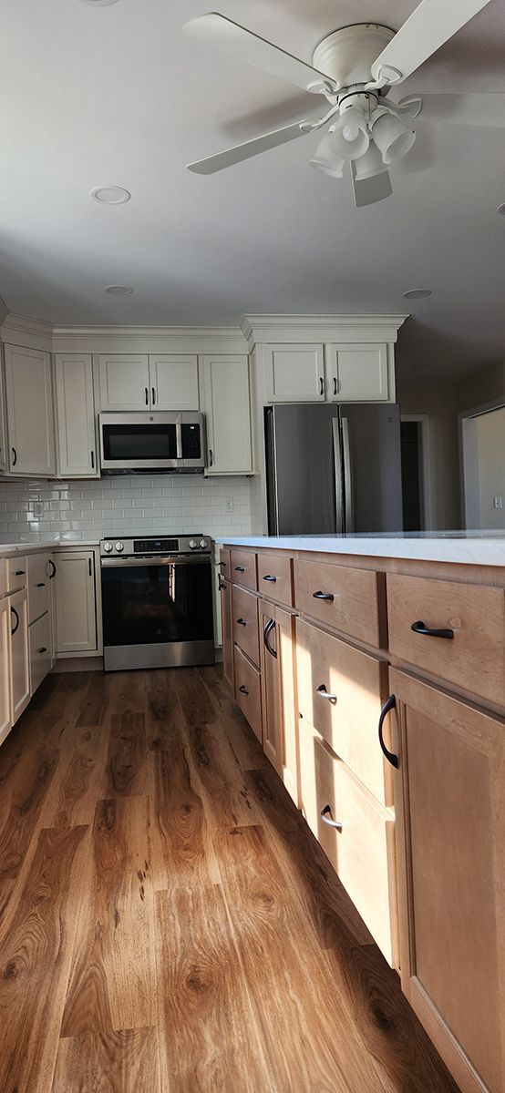 kitchen with stainless steel appliances, wood flooring and island