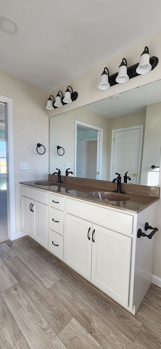 master bathroom with double sink, window and light fixtures