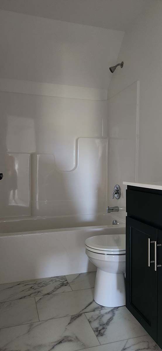 A bathroom with a toilet , sink , bathtub and shower.