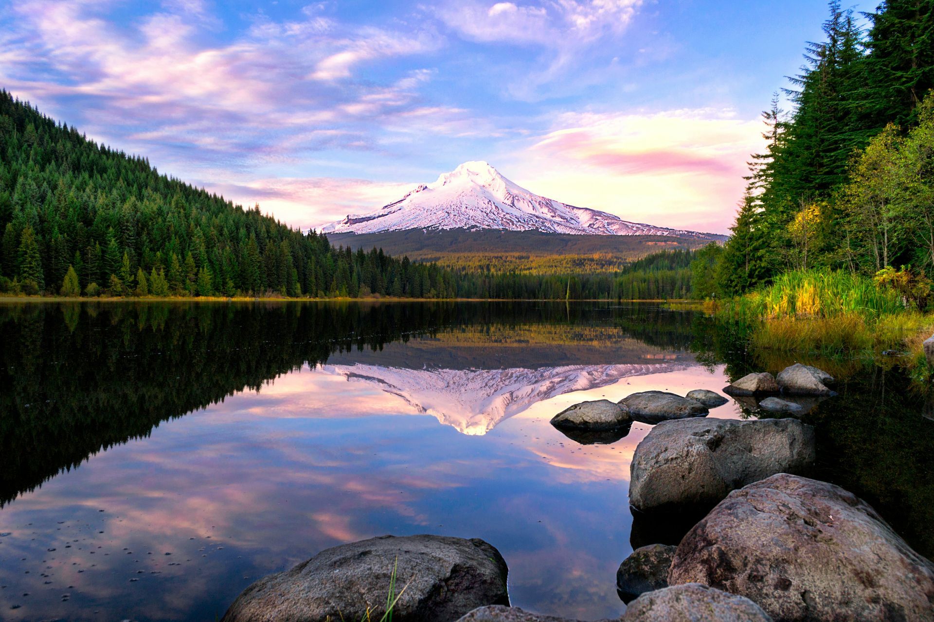 A lake with a mountain in the background and trees on the shore