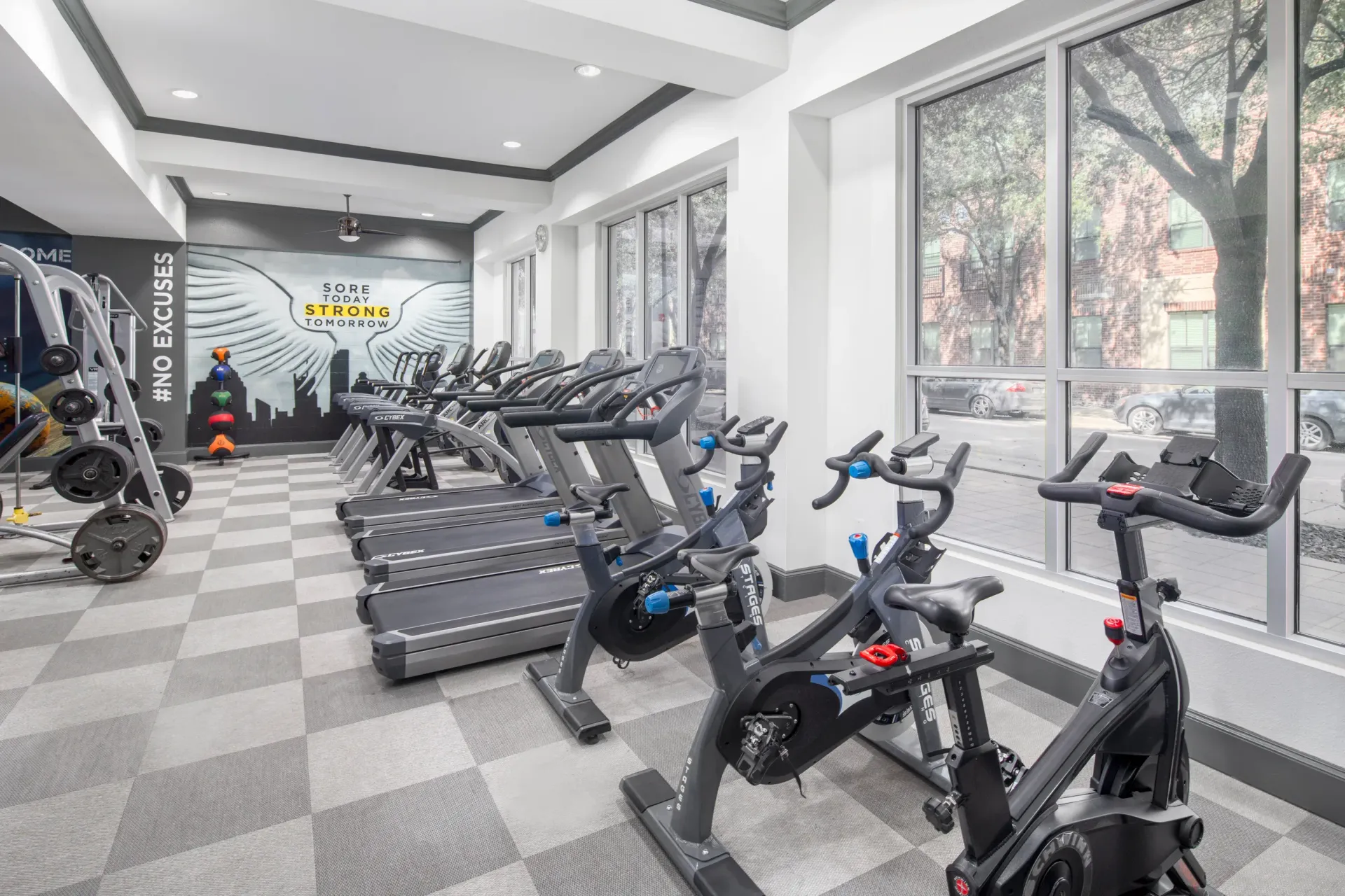 Well-equipped gym with cardio machines and a motivational wall mural