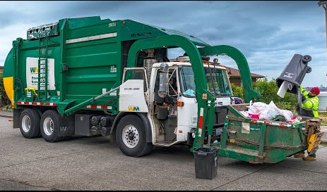 Green dump truck on a road.