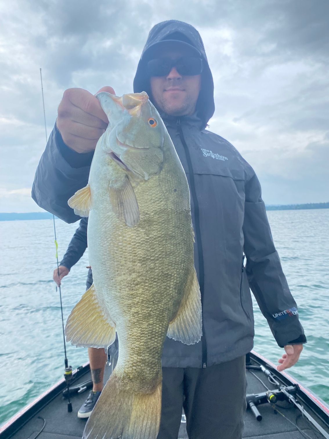 A man is holding a large fish on a boat.