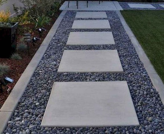 A concrete walkway surrounded by gravel and rocks.